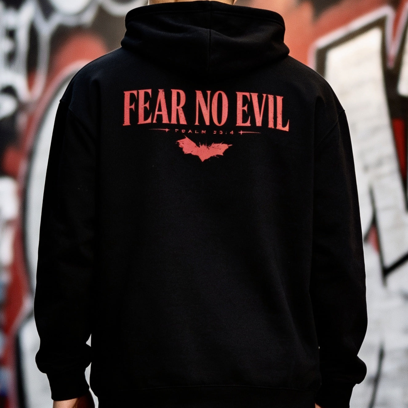 Black hoodie with 'Fear No Evil' text on the back against a graffiti-covered wall.